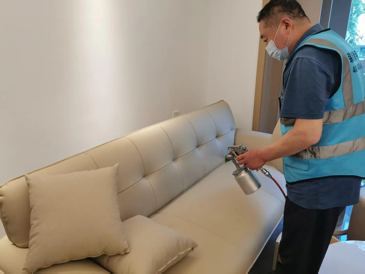 工作人员对沙发表面进行喷涂处理