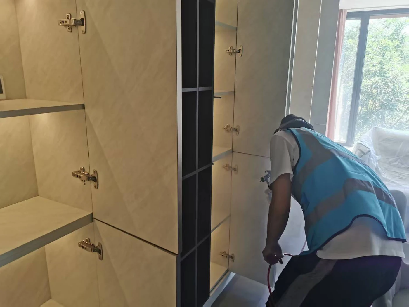 工作人员对柜体下部进行喷涂处理