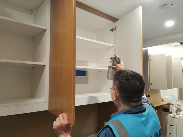 工作人员对柜体内部进行喷涂处理